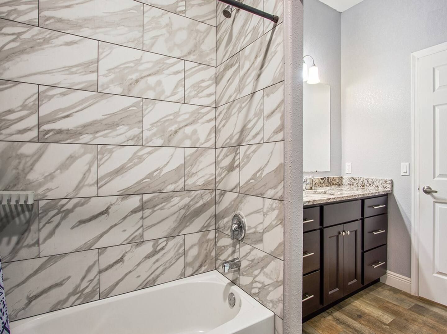 A bathroom with a bathtub , sink , and shower.