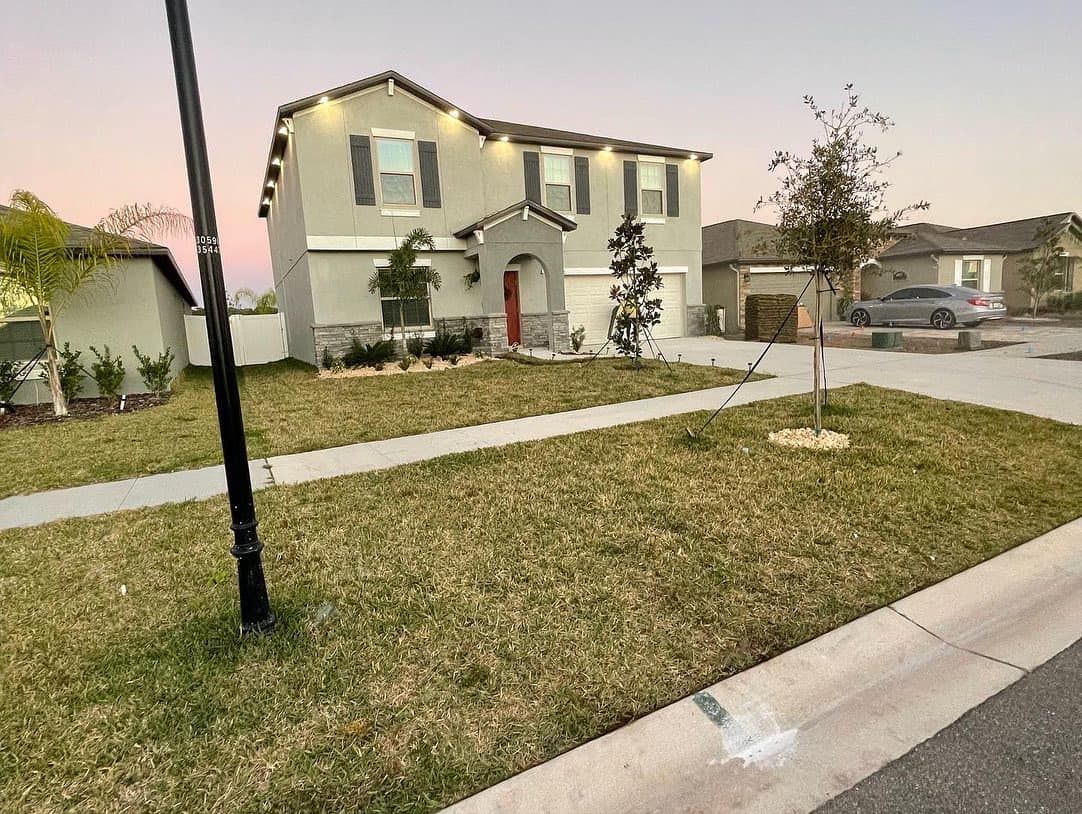 A house with a lot of grass in front of it and a car parked in front of it.