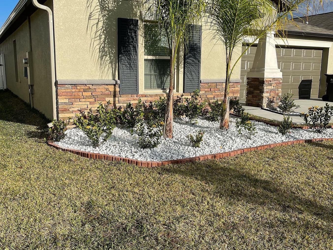 A house with a lush green lawn and a garden in front of it.