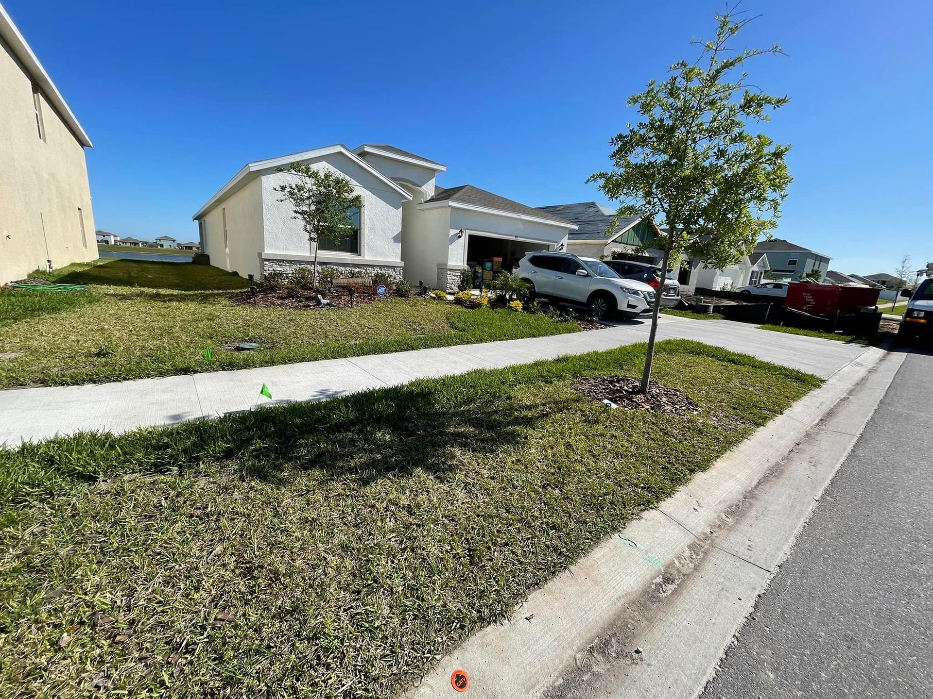 A car is parked in front of a house in a residential neighborhood.