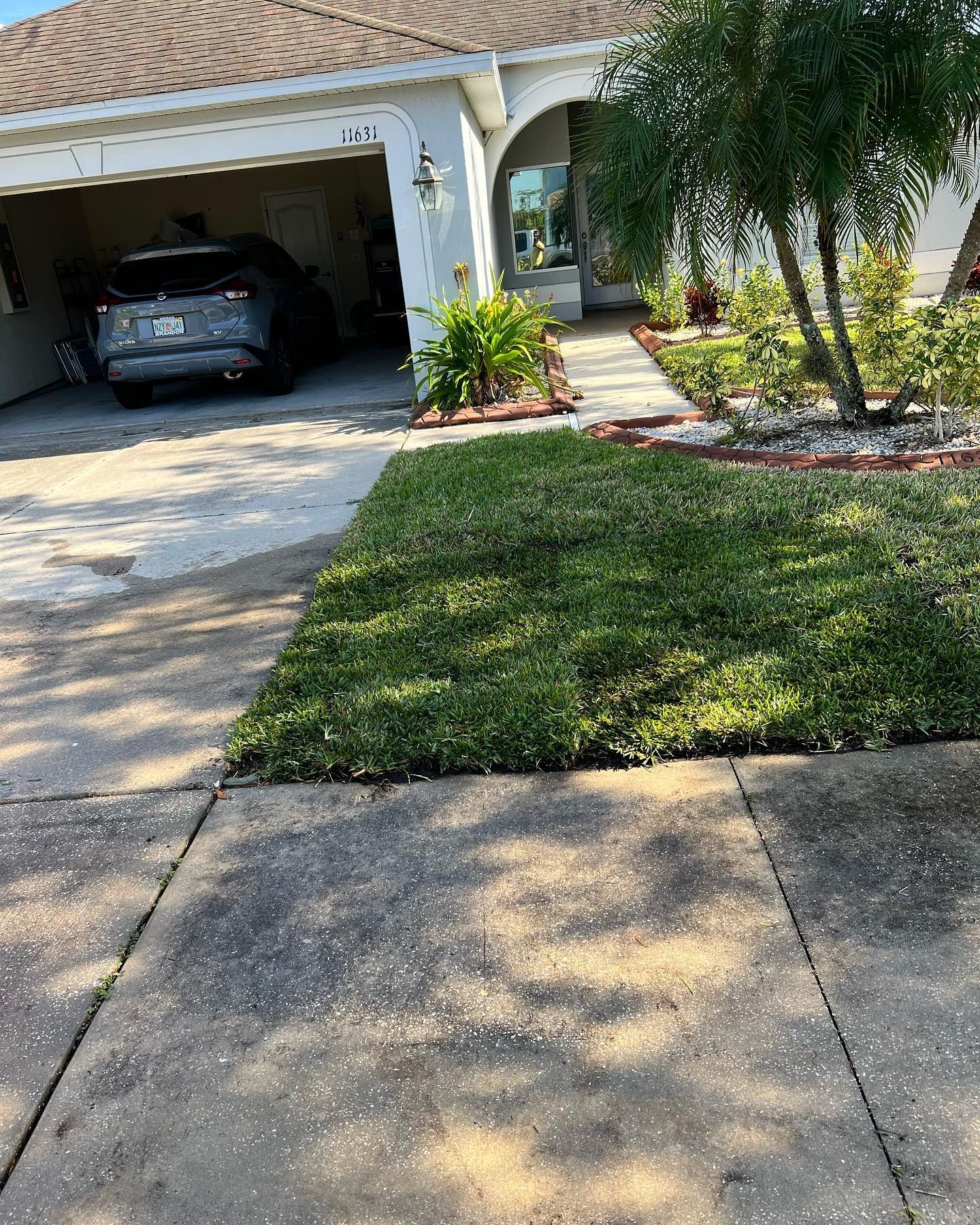 A car is parked in a driveway in front of a house.