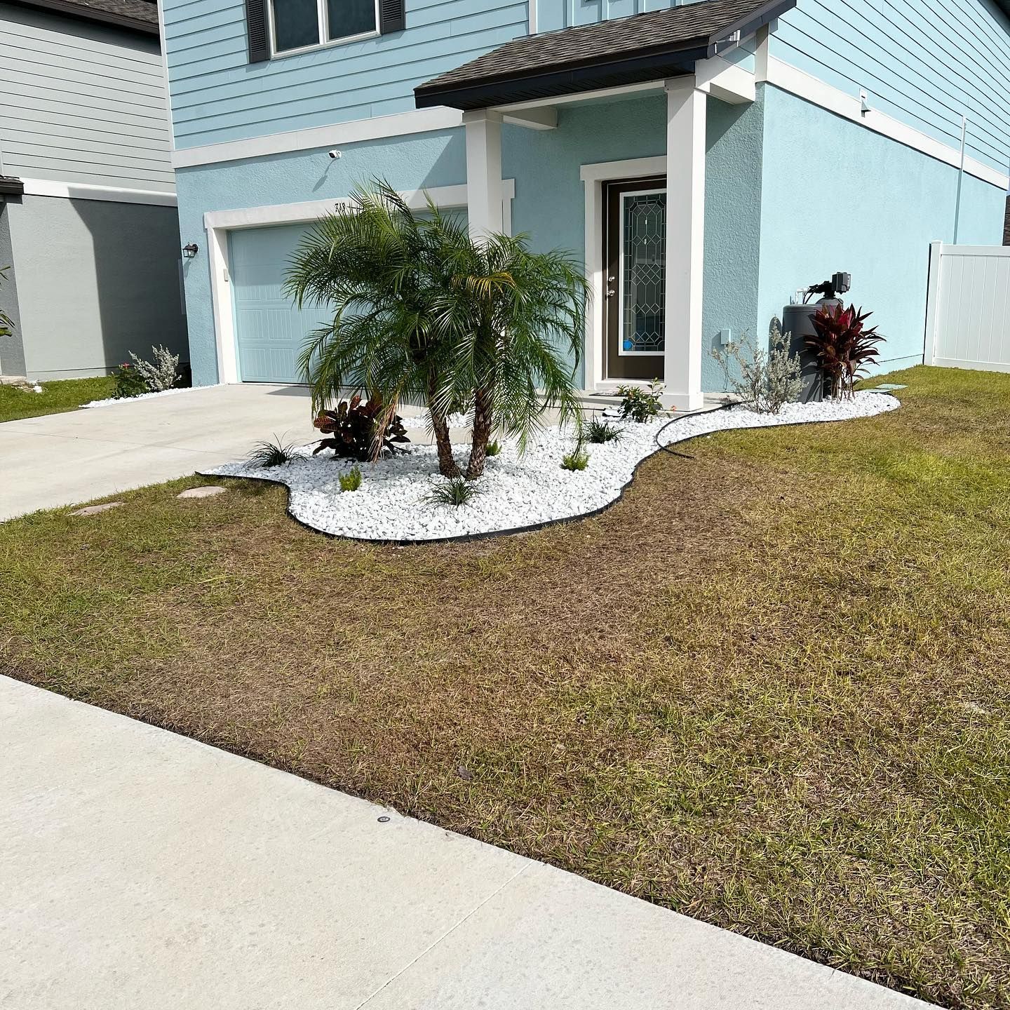A blue house with a lush green lawn in front of it