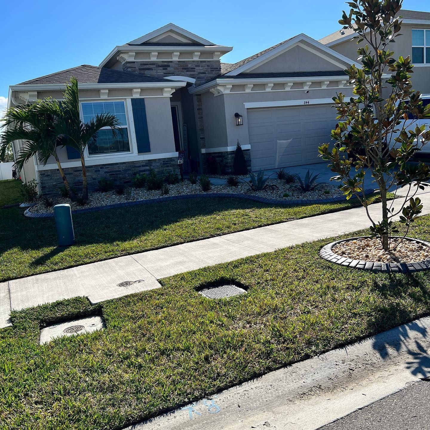 A house with a lot of grass and a tree in front of it