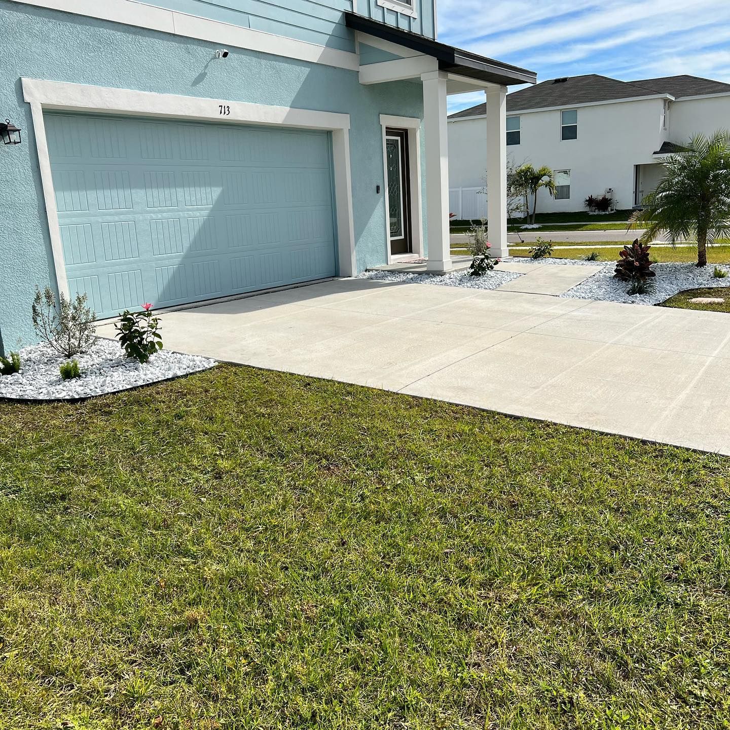 A house with a blue garage door and a white porch
