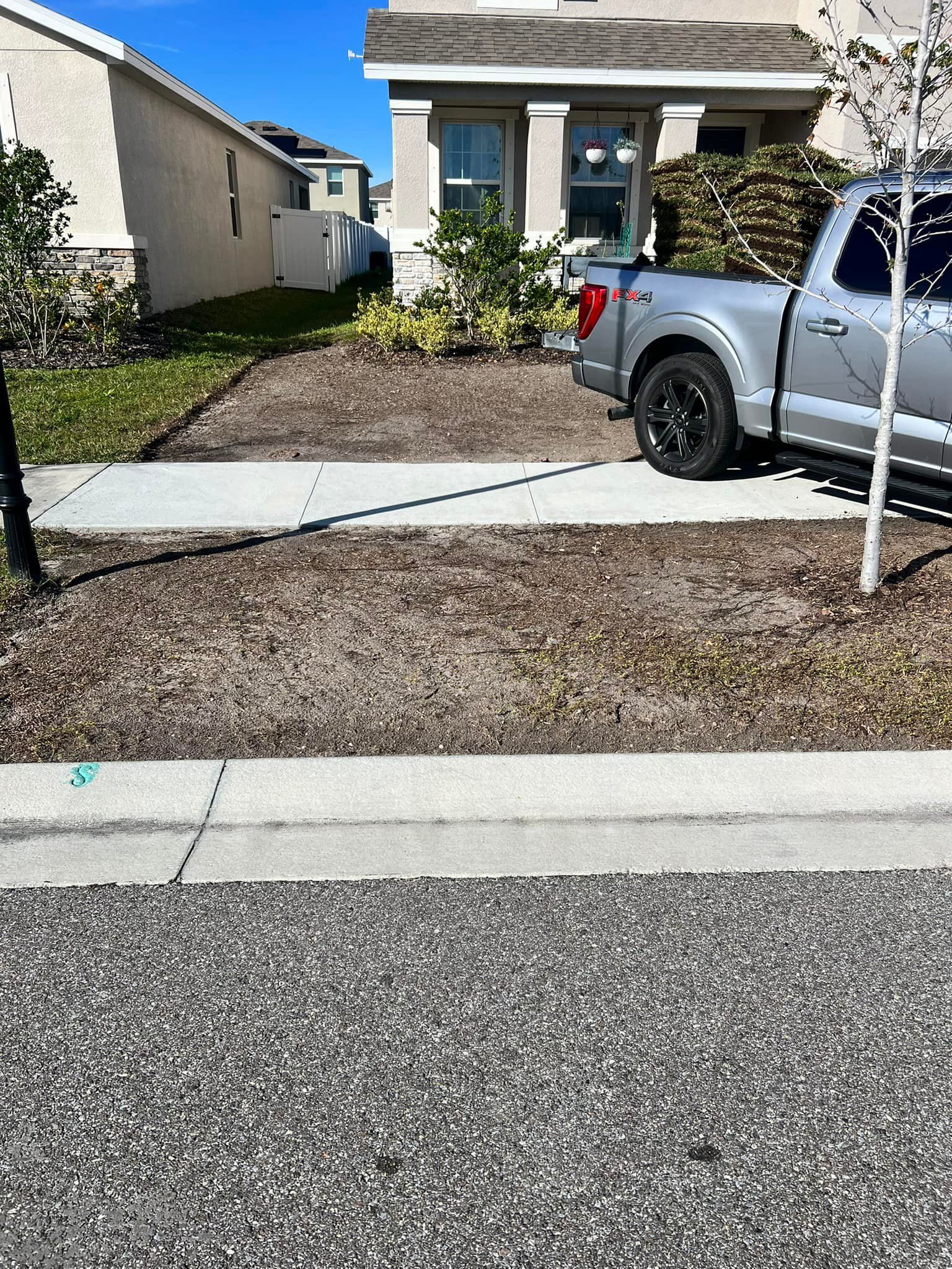 A silver truck is parked in front of a house.