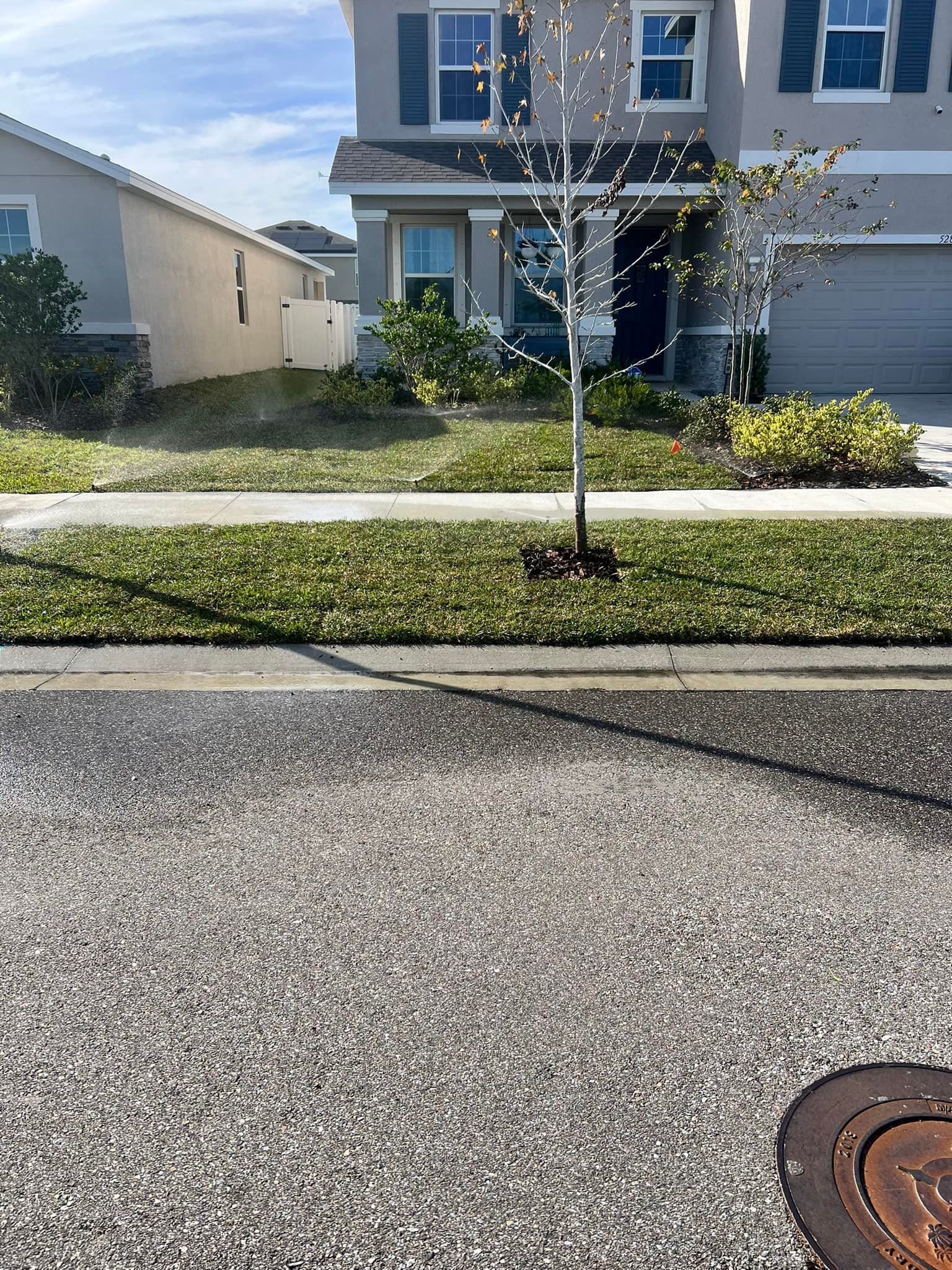There is a manhole cover in front of a house.