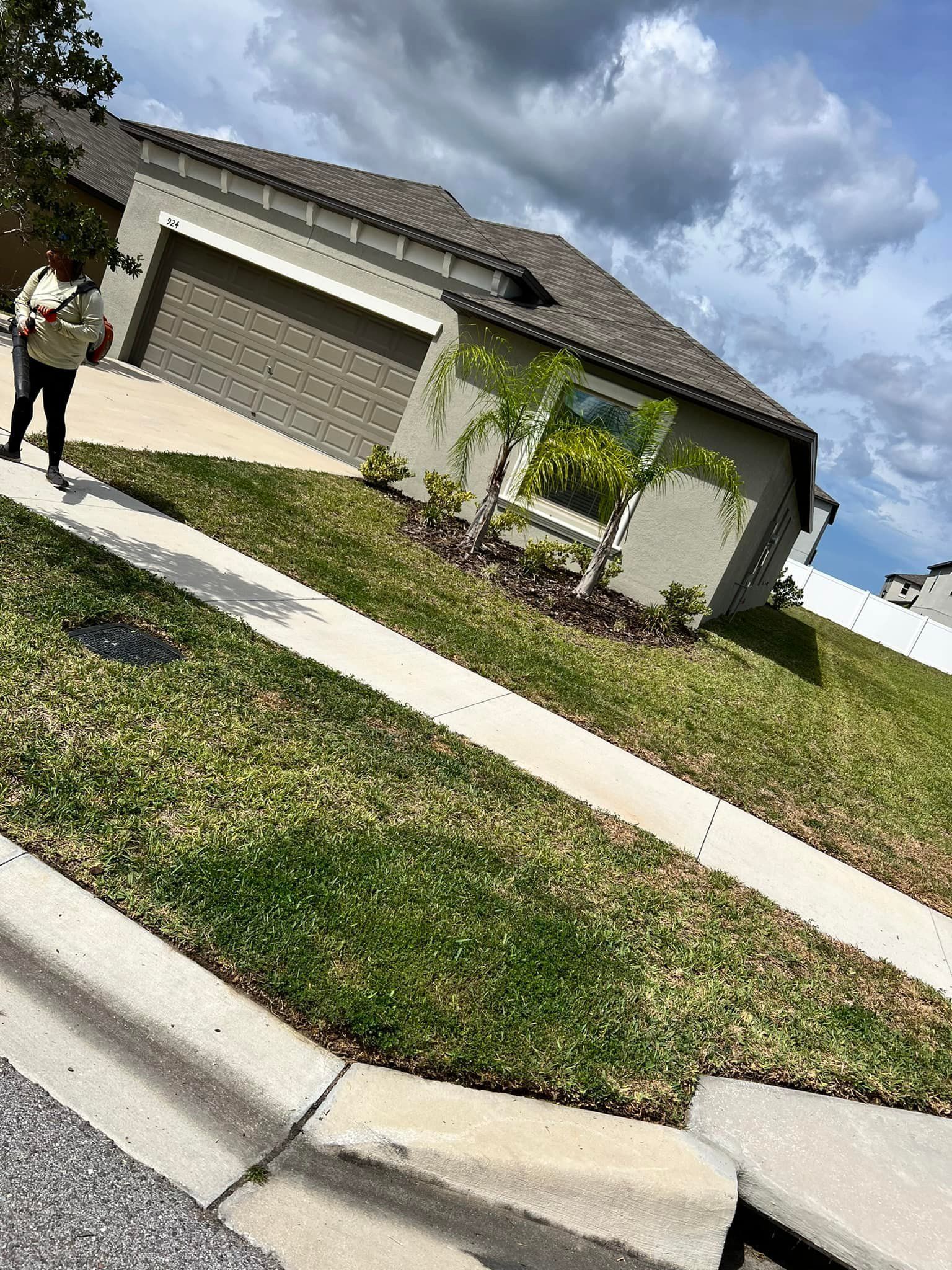 A man is walking down a sidewalk in front of a house.
