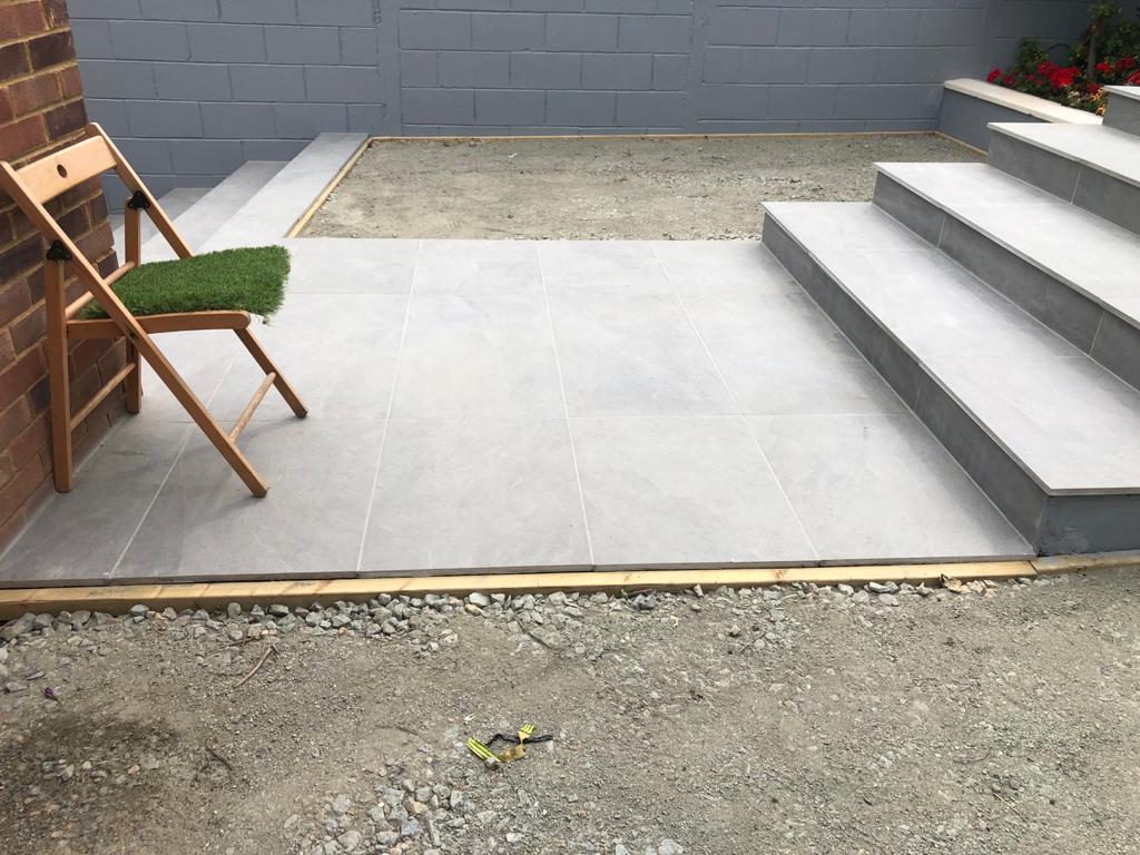 A chair is sitting on a tiled patio next to stairs.