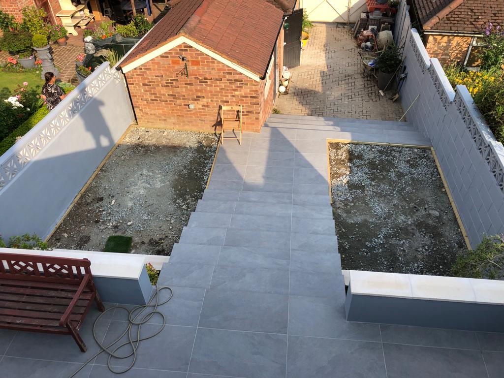 An aerial view of a backyard with a brick building and a bench.