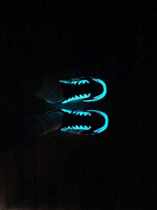 A pair of glow in the dark shoes with shark teeth on them.
