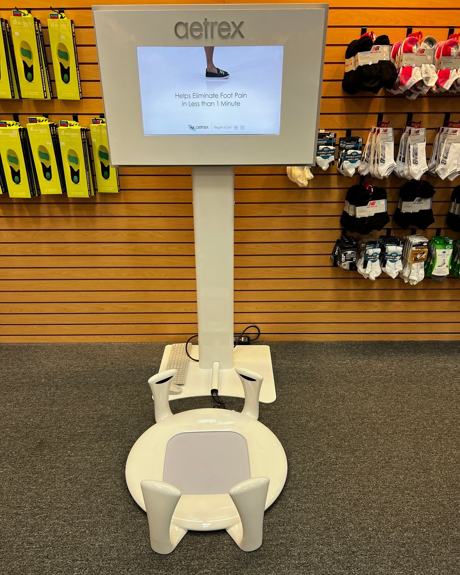 A oetrex machine is sitting in front of a wall of socks