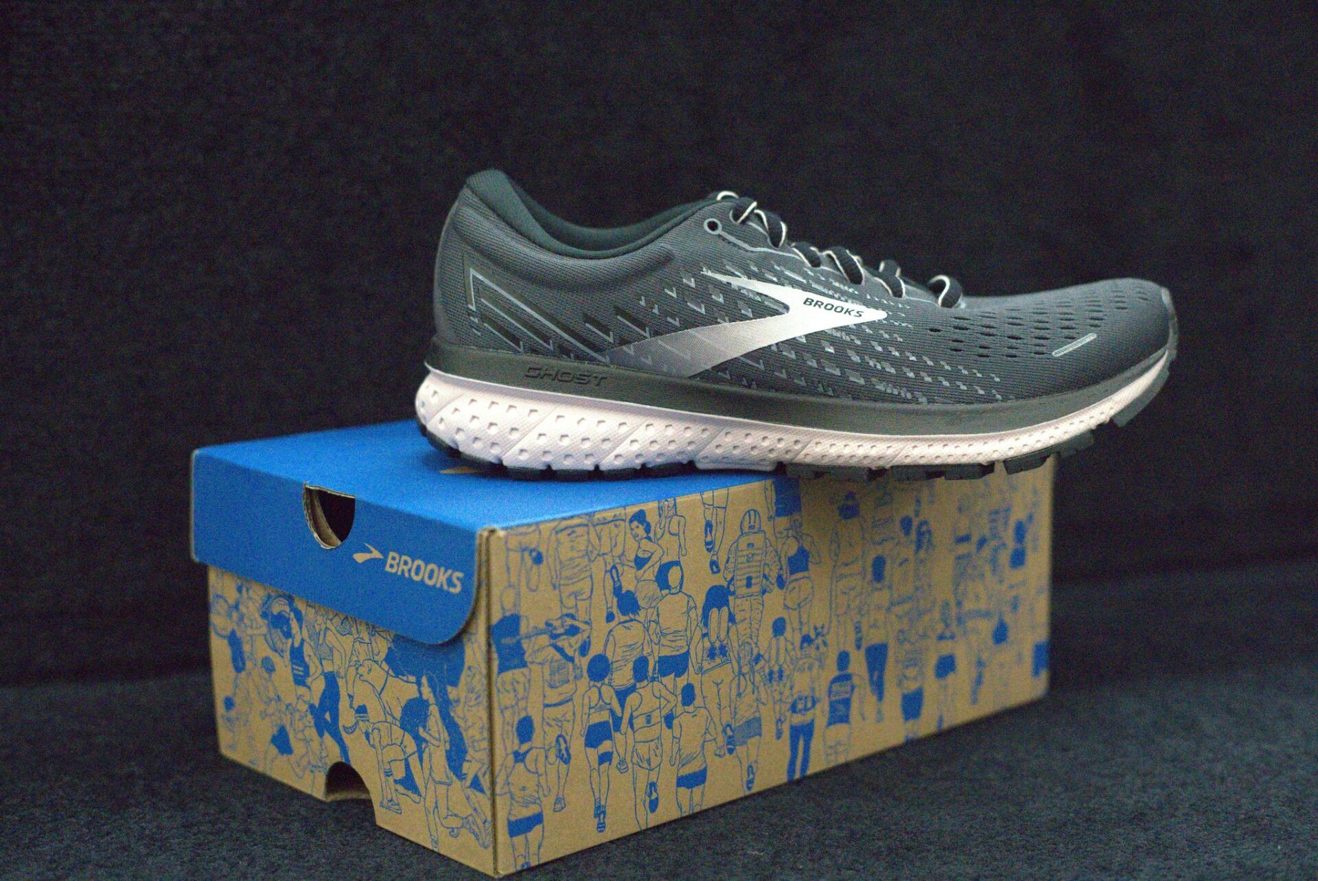 A pair of brooks running shoes sitting on top of a cardboard box.