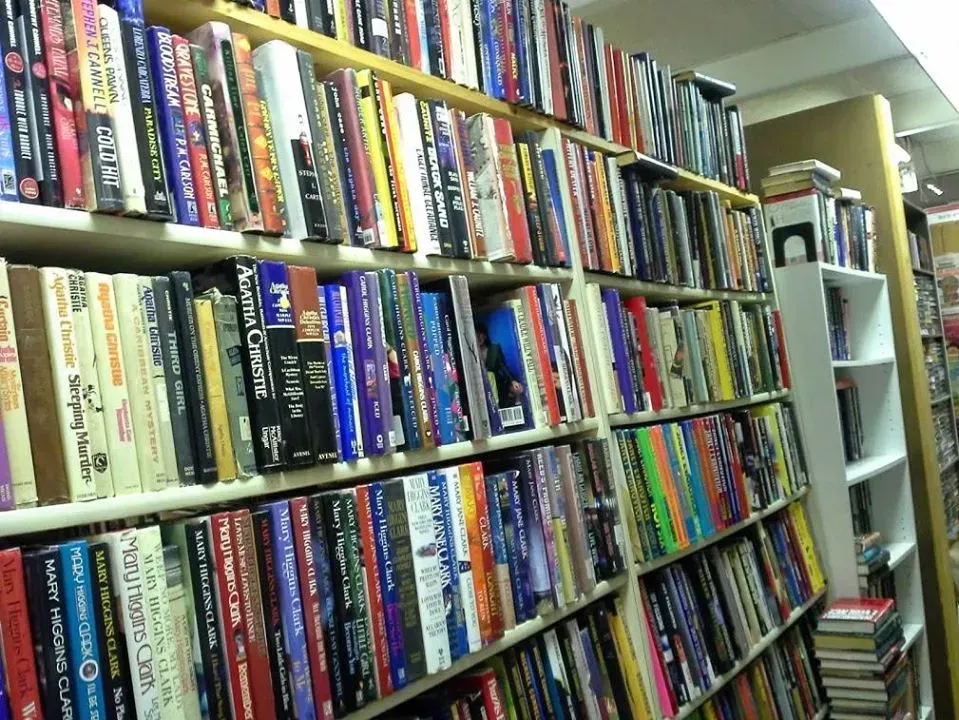 Shelves packed with books in a bookstore, showcasing various spines.