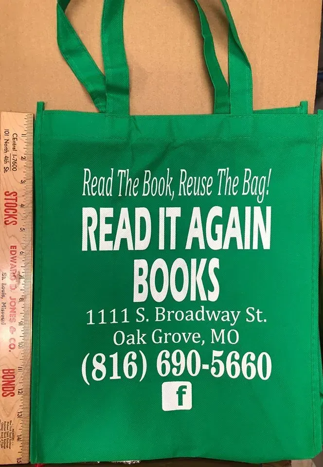 Green tote bag for Read It Again Books, Oak Grove, MO. White text includes address, phone number, and Facebook icon.