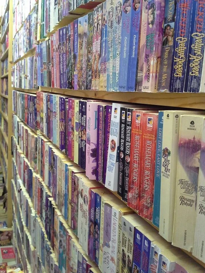 Rows of VHS tapes on shelves in a store, many with colorful spines.