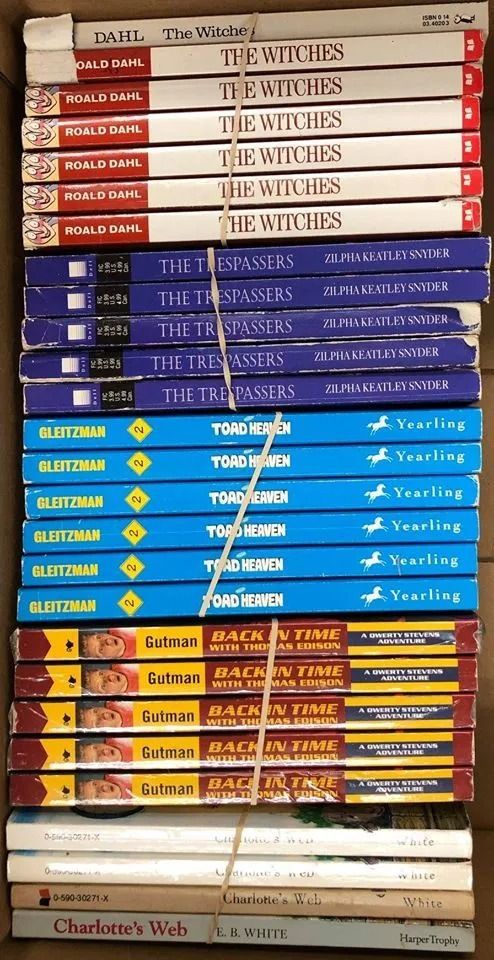 Books stacked in a box, titles include 