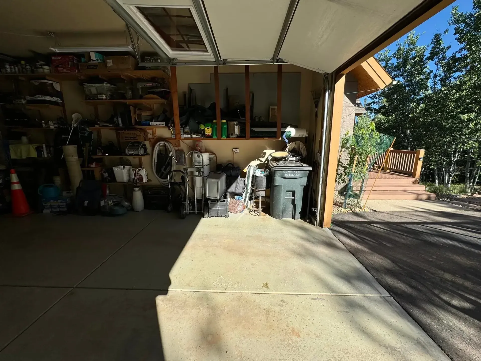 A garage filled with lots of stuff and a concrete floor.