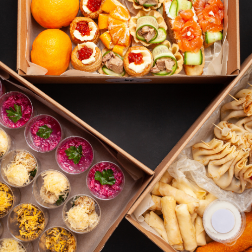 Three boxes filled with different types of food on a table