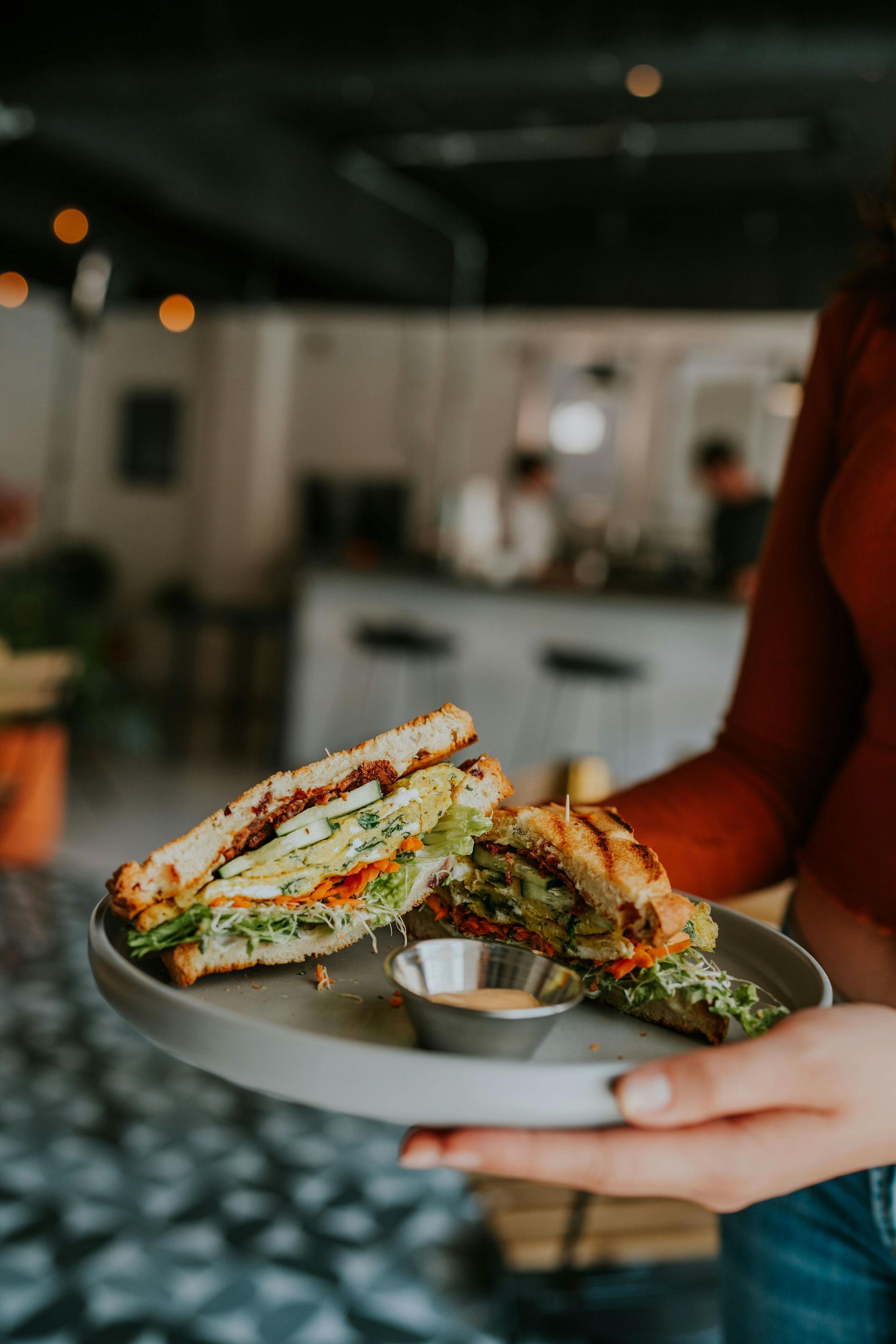 A person is dipping a piece of bread into a pan of food.