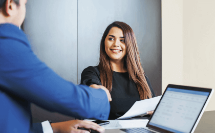A lady shaking hands with a successful job candidate
