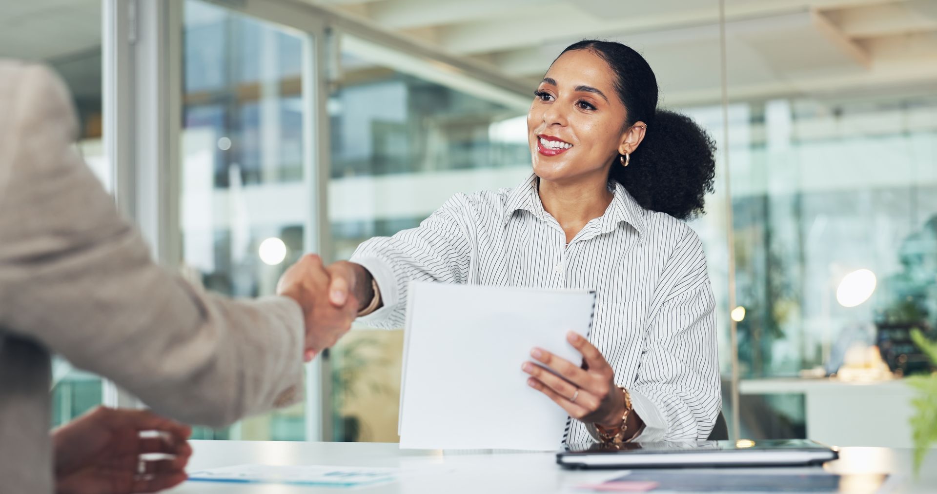 Interviewing women shaking hands with a job candidate at the end of the interview.