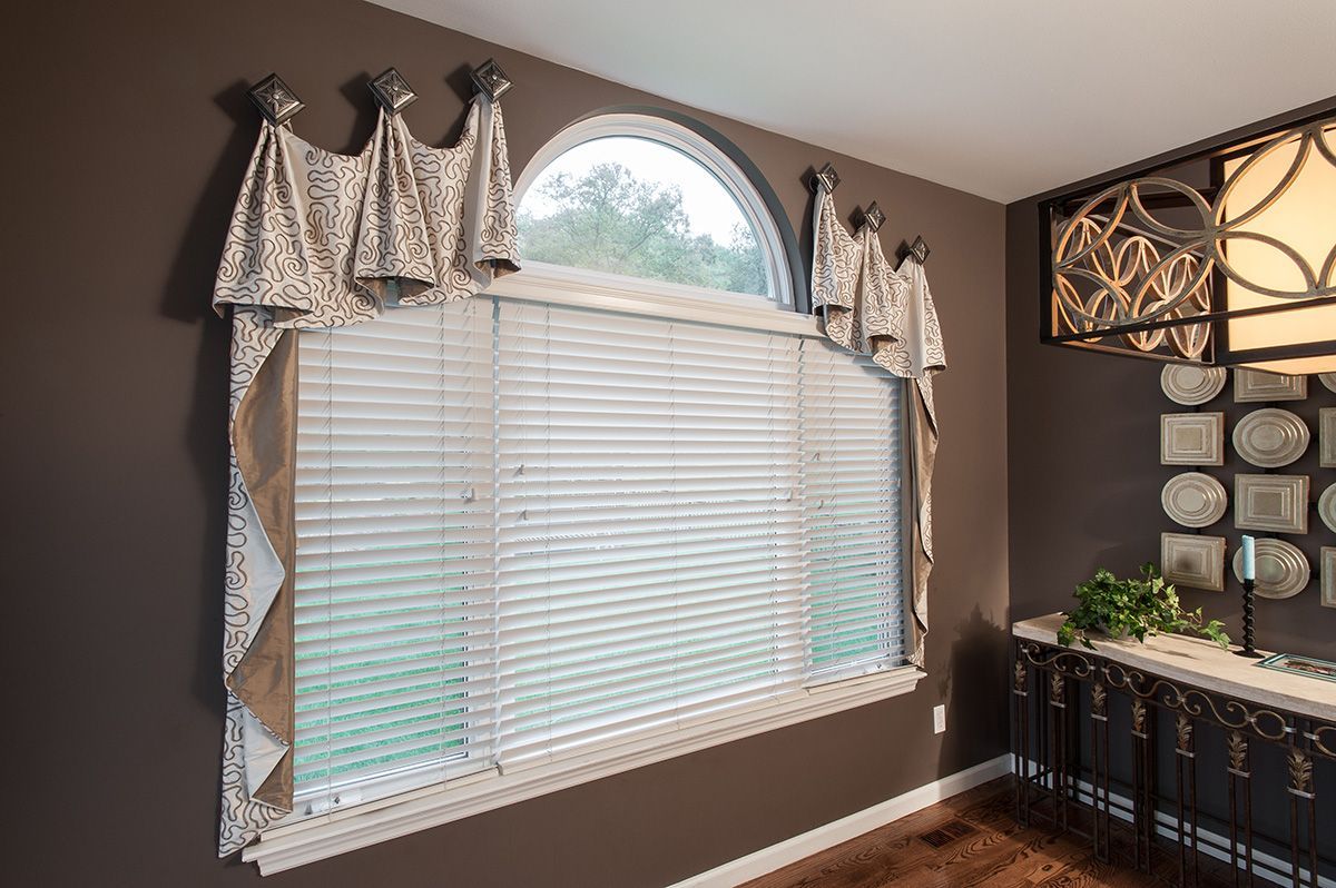A room with a large window and blinds on it.