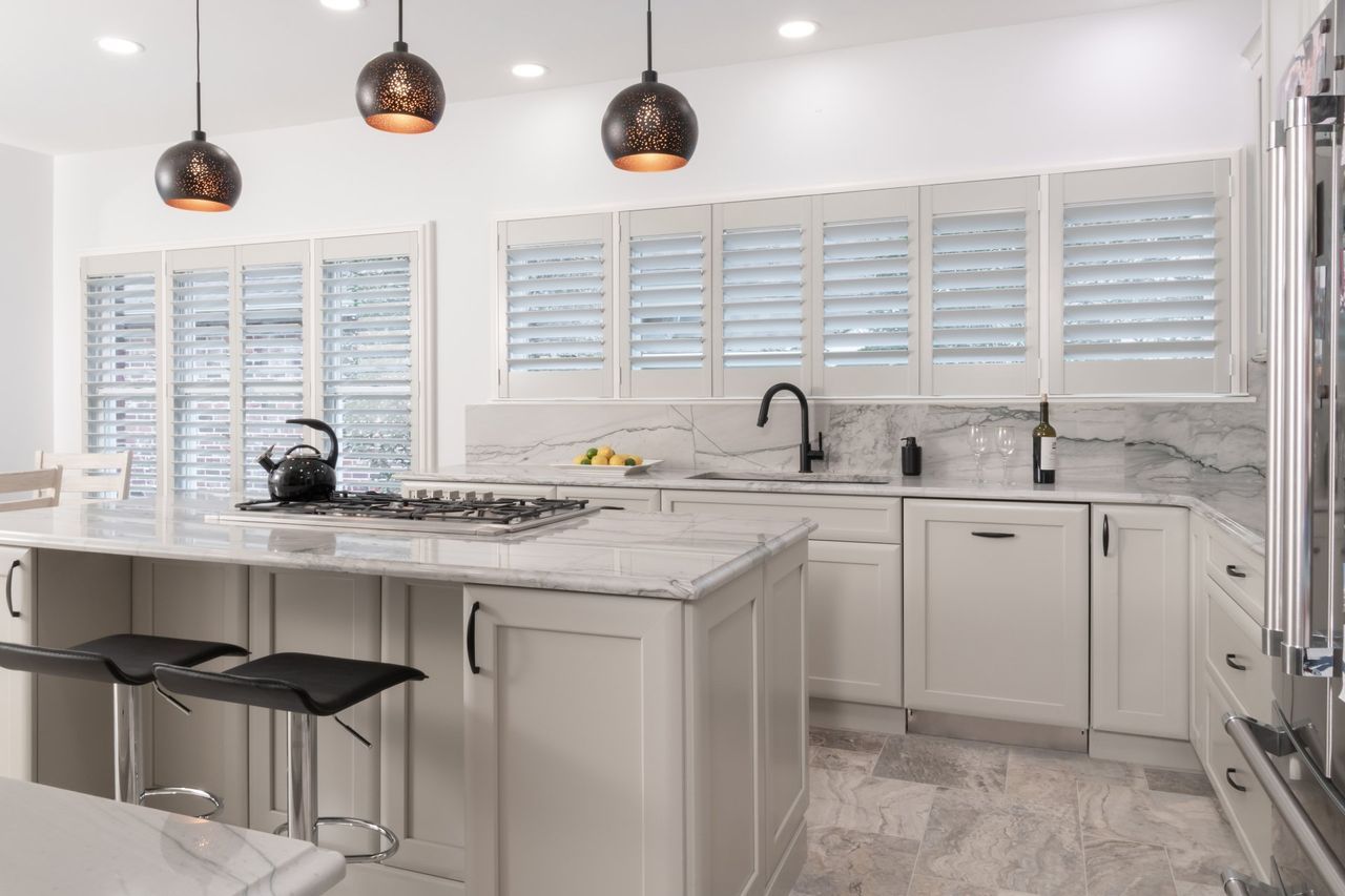 A kitchen with white cabinets , granite counter tops , and stainless steel appliances.