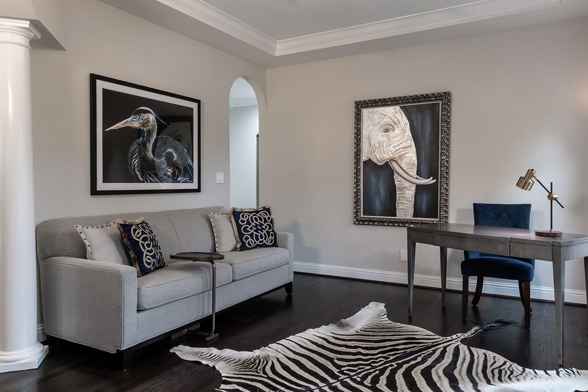 A living room with a couch , desk , chair and zebra rug