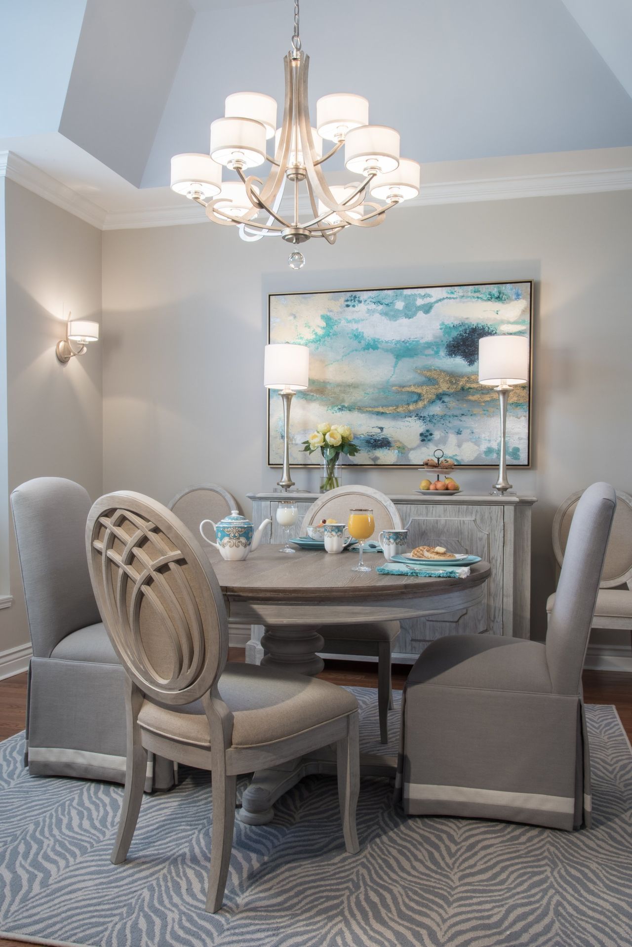 A dining room with a table and chairs and a chandelier.