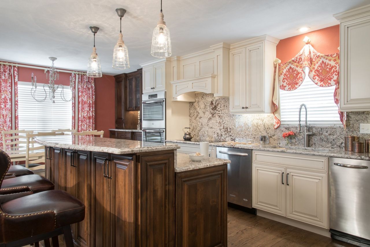 A kitchen with white cabinets , granite counter tops , stainless steel appliances and a large island.