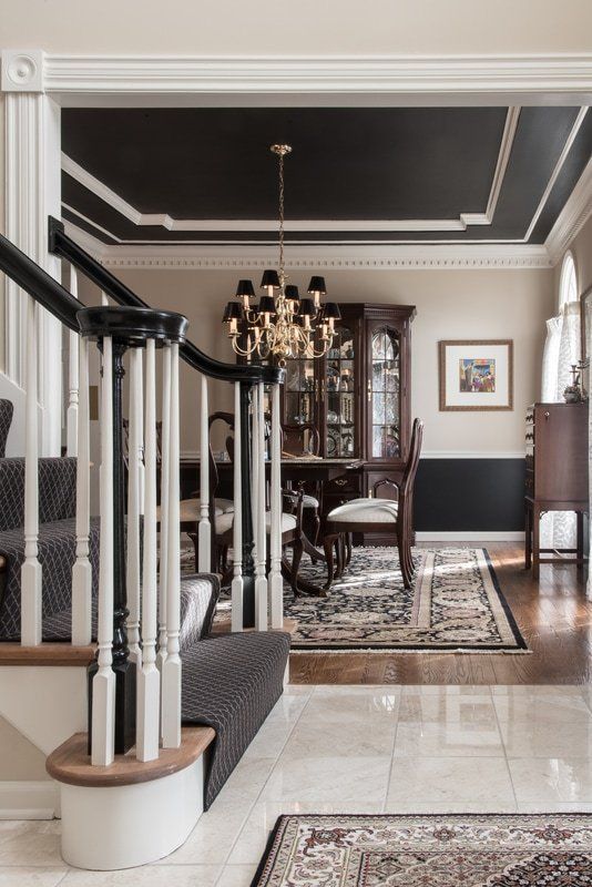 A staircase leading to a dining room in a house with a black ceiling.