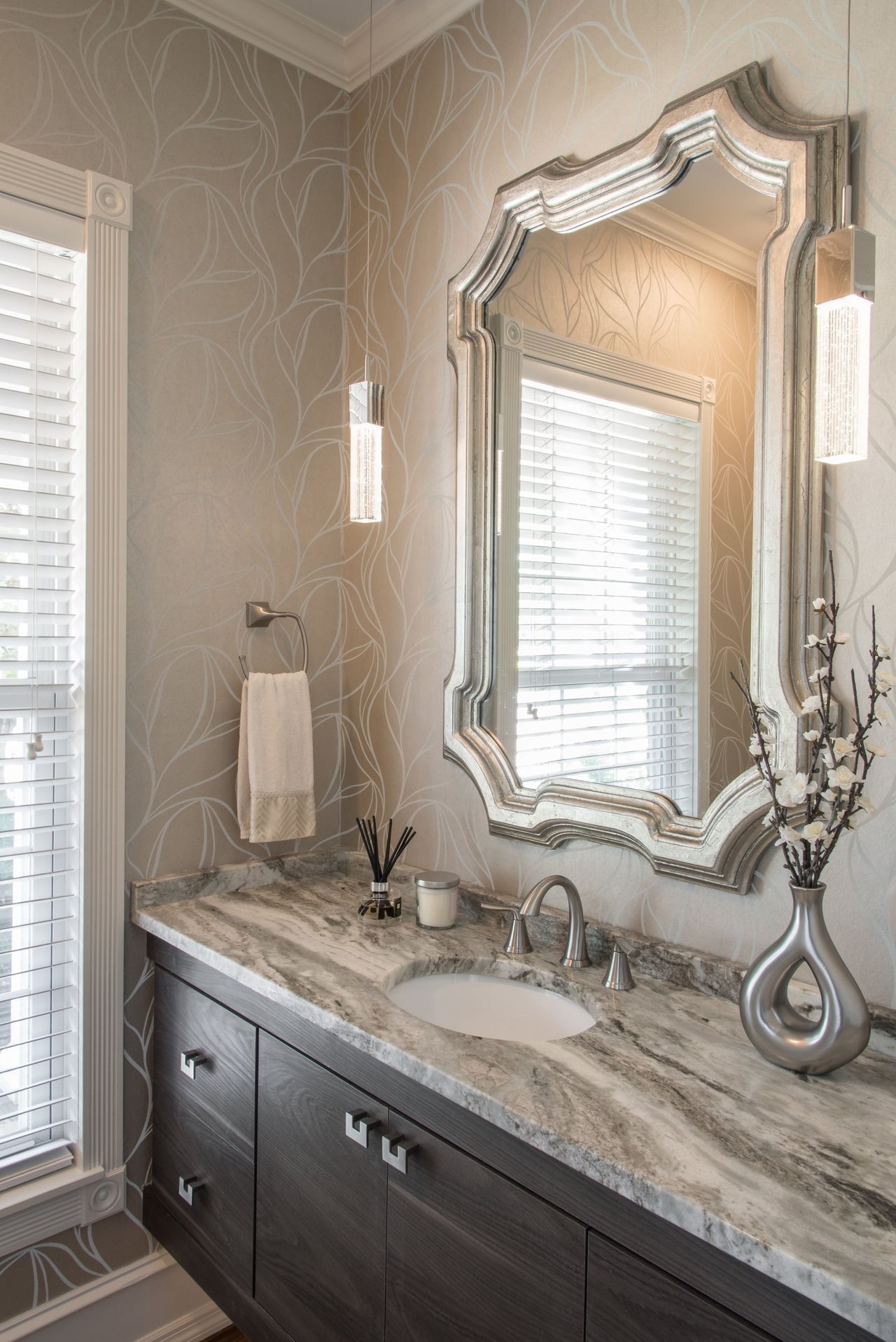 A bathroom with a sink , mirror and window.