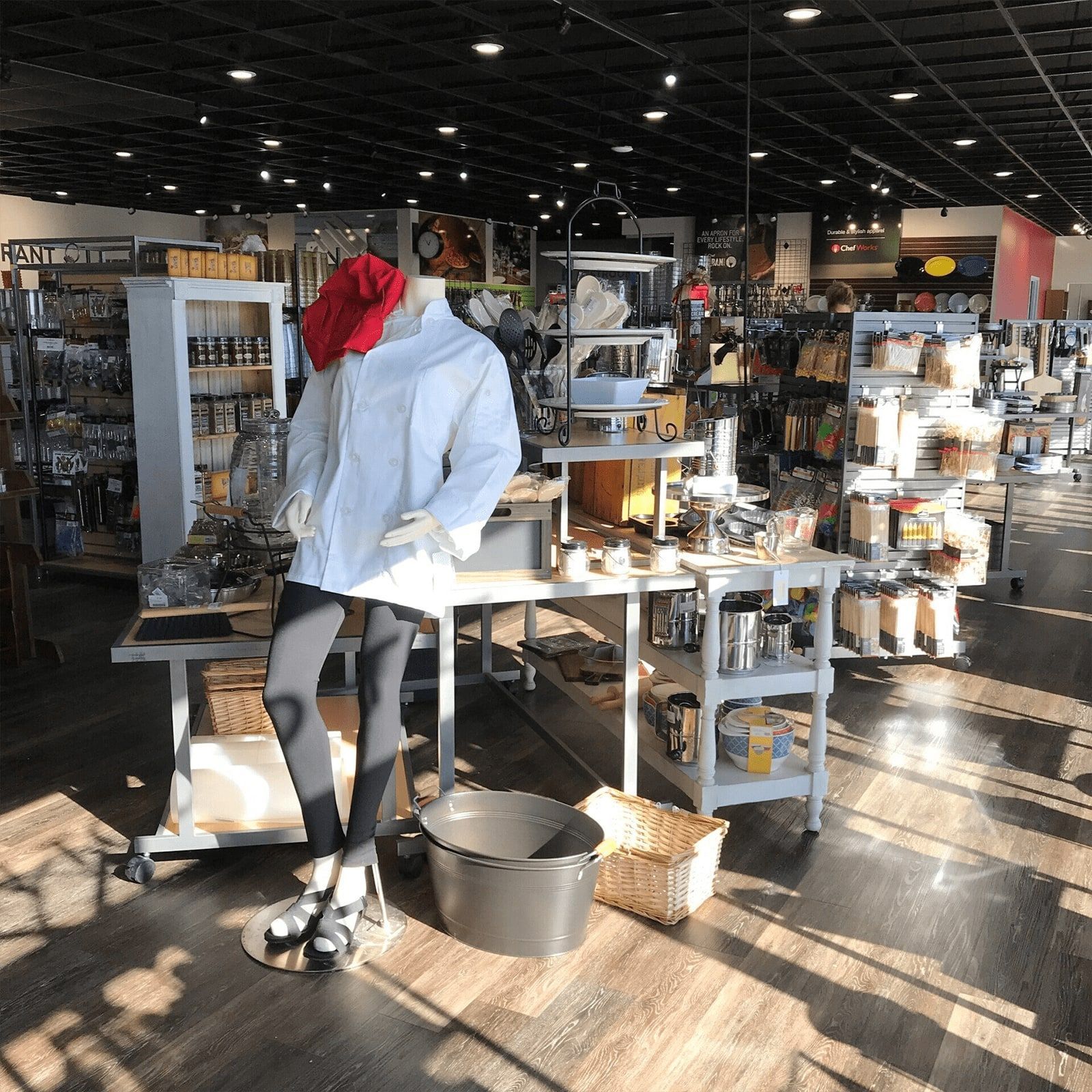 A store with a mannequin wearing a white shirt and a red hat