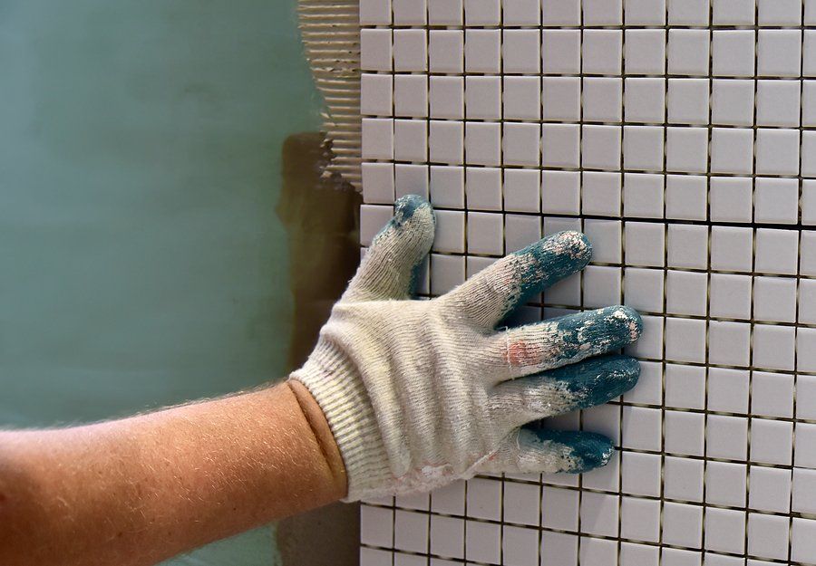 worker installing bathroom tiles
