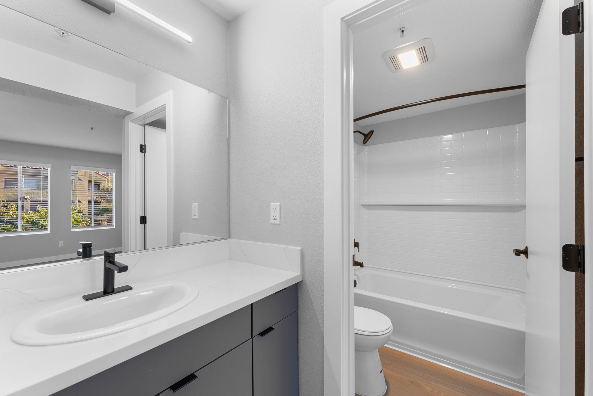 A bathroom with a sink, toilet, and bathtub/shower.