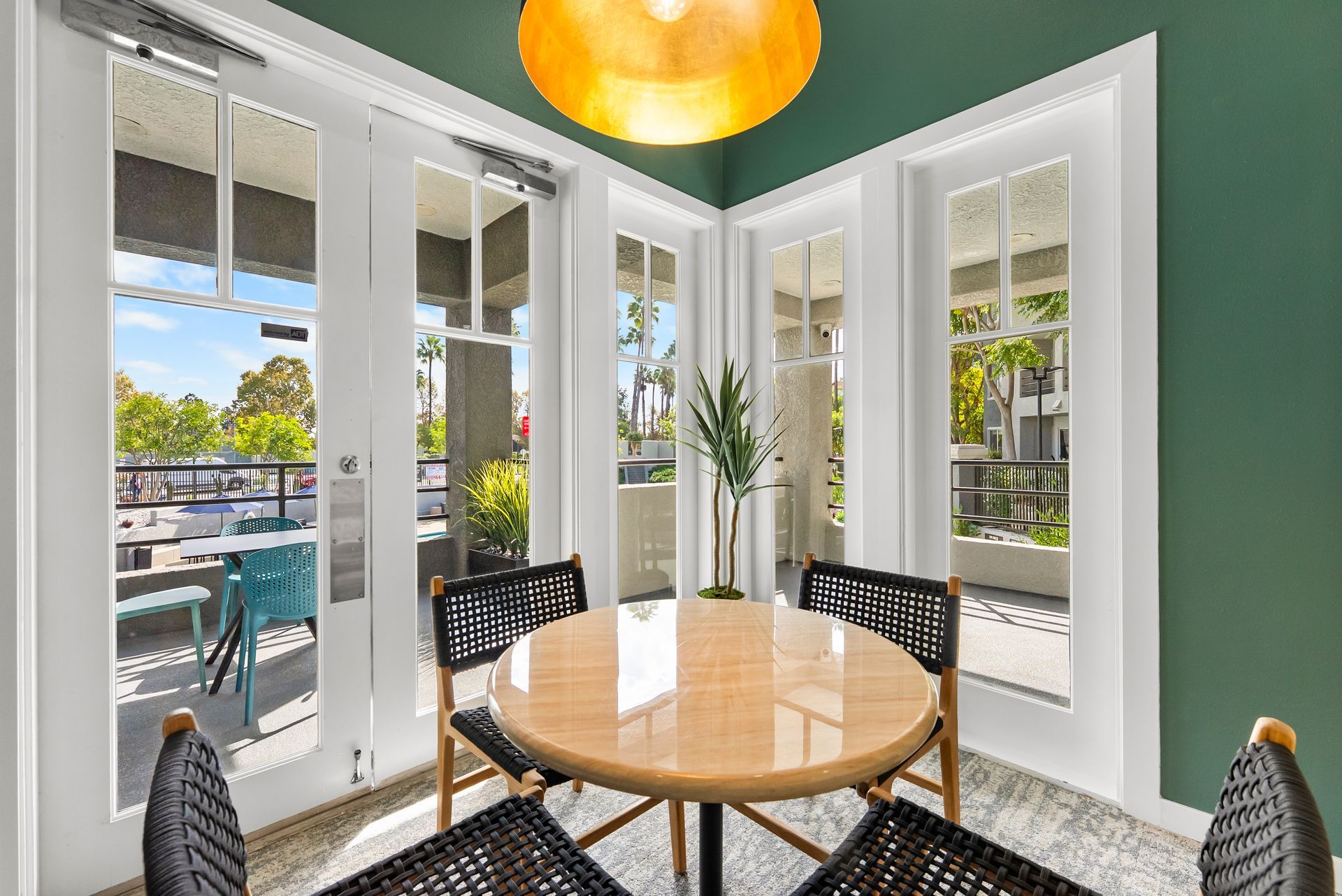 Small dining area with a round table, four chairs, and French doors leading to a balcony.