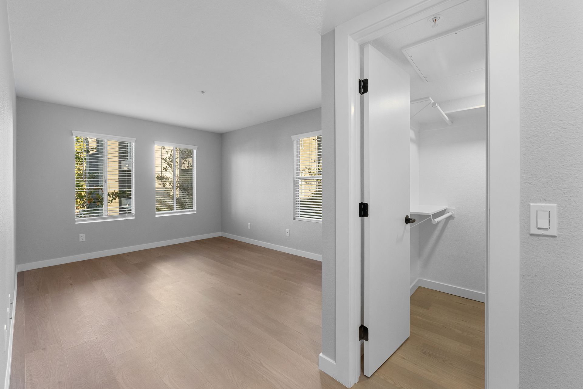 Bedroom with wood floors and open door to walk in closet