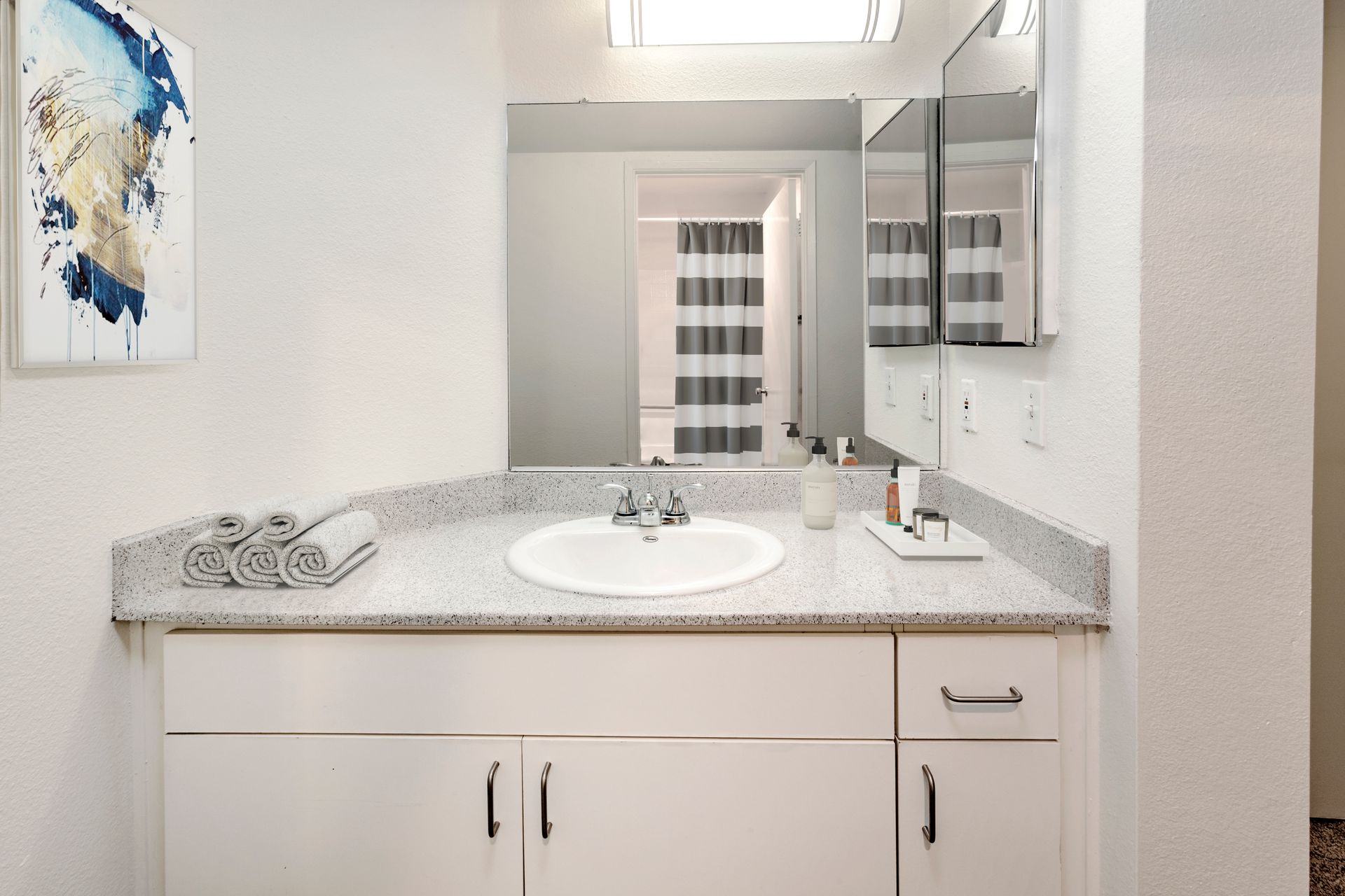 a bathroom with a sink , mirror and cabinets