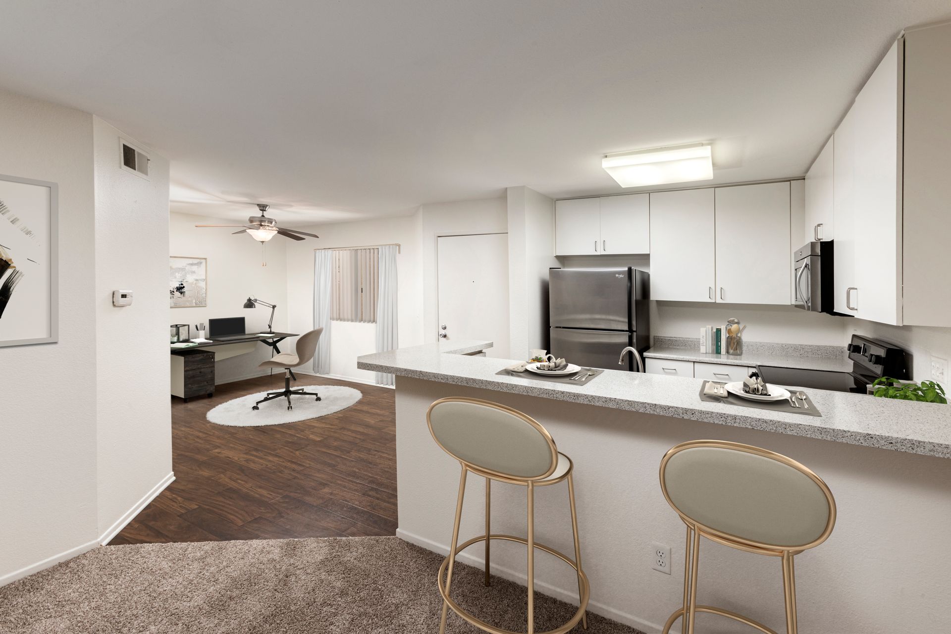 a kitchen with a bar and stools in a house .