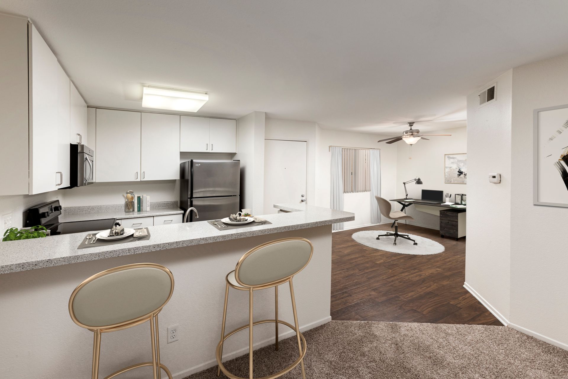 a kitchen with a bar and stools in a living room .