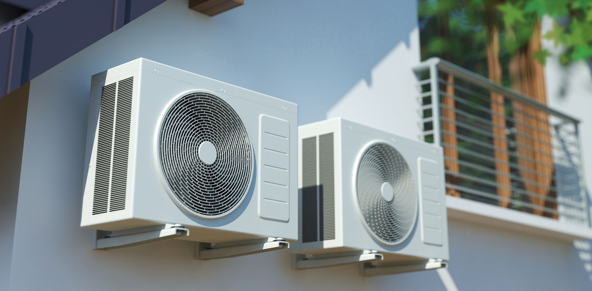 Two outdoor air conditioning units mounted on a white wall.
