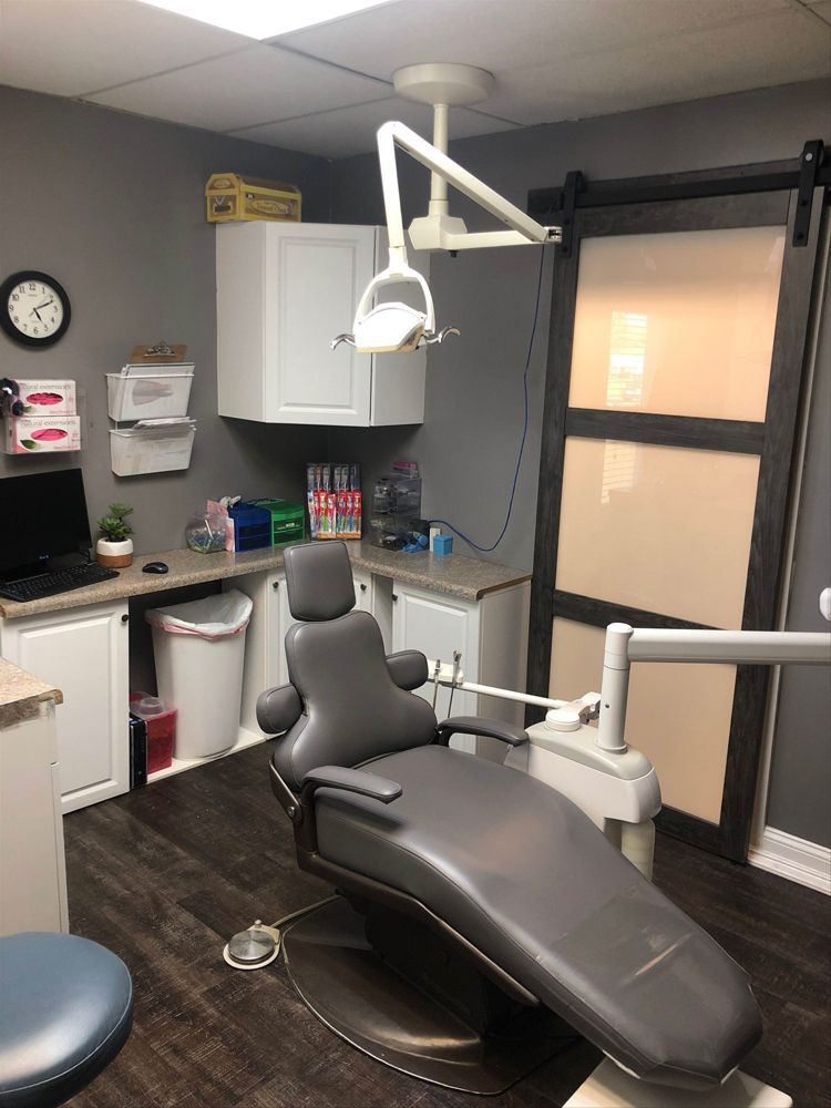 There is a dental chair in the middle of the room.