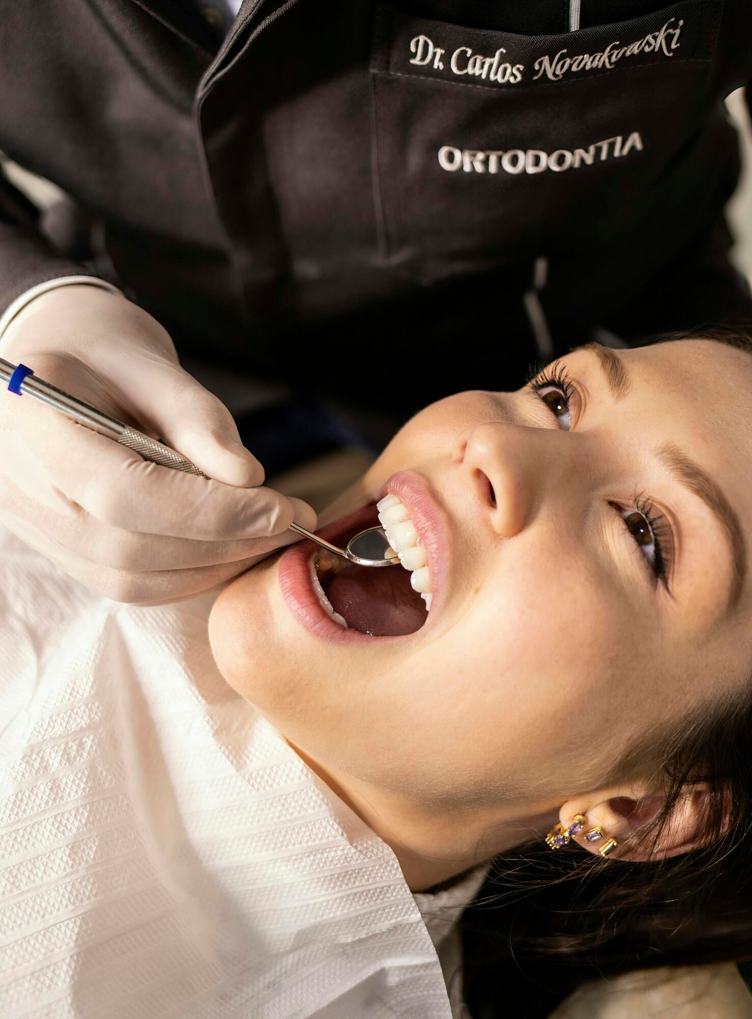 A woman is getting her teeth examined by a dentist.