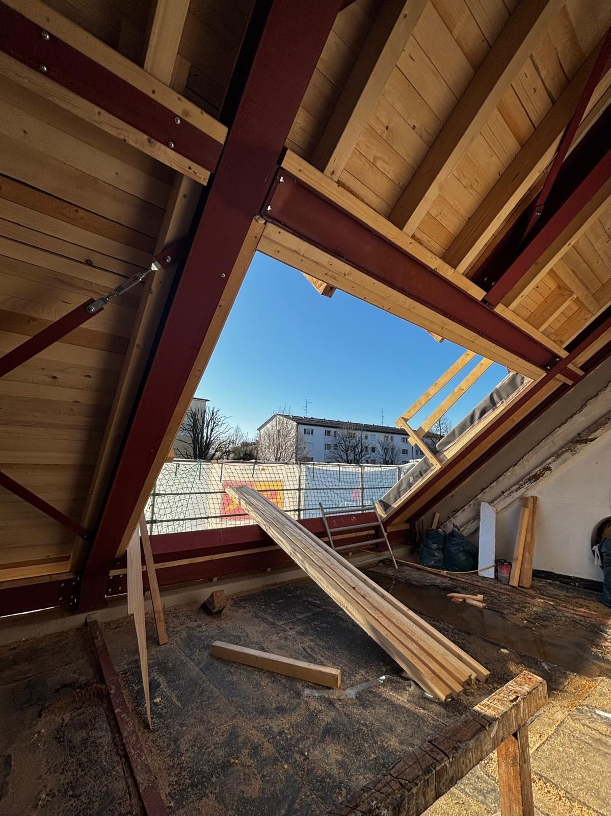 Dachausbau mit geöffnetem Dachfenster und Holzbalken