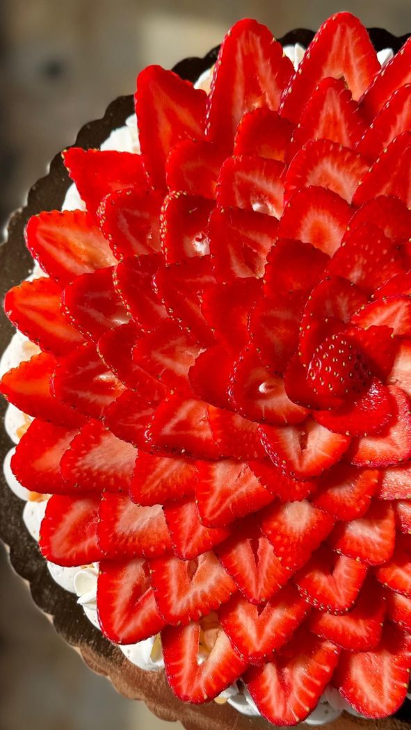 A pie with strawberries and whipped cream on top of it