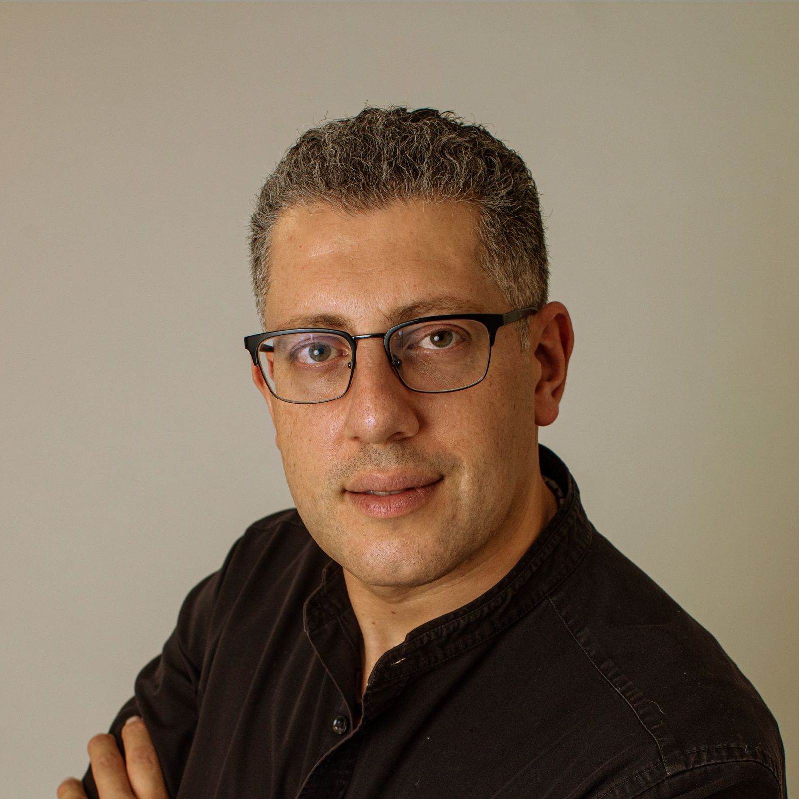 Ein Mann mit Brille und schwarzem Hemd steht in einem Kreis.