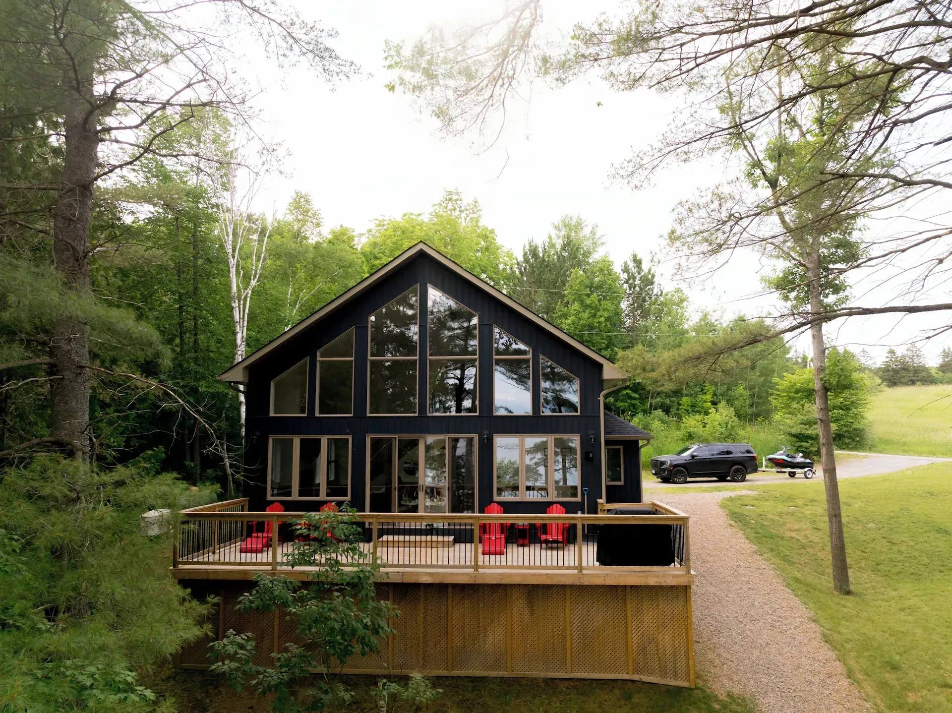 A black house with a lot of windows and a large deck