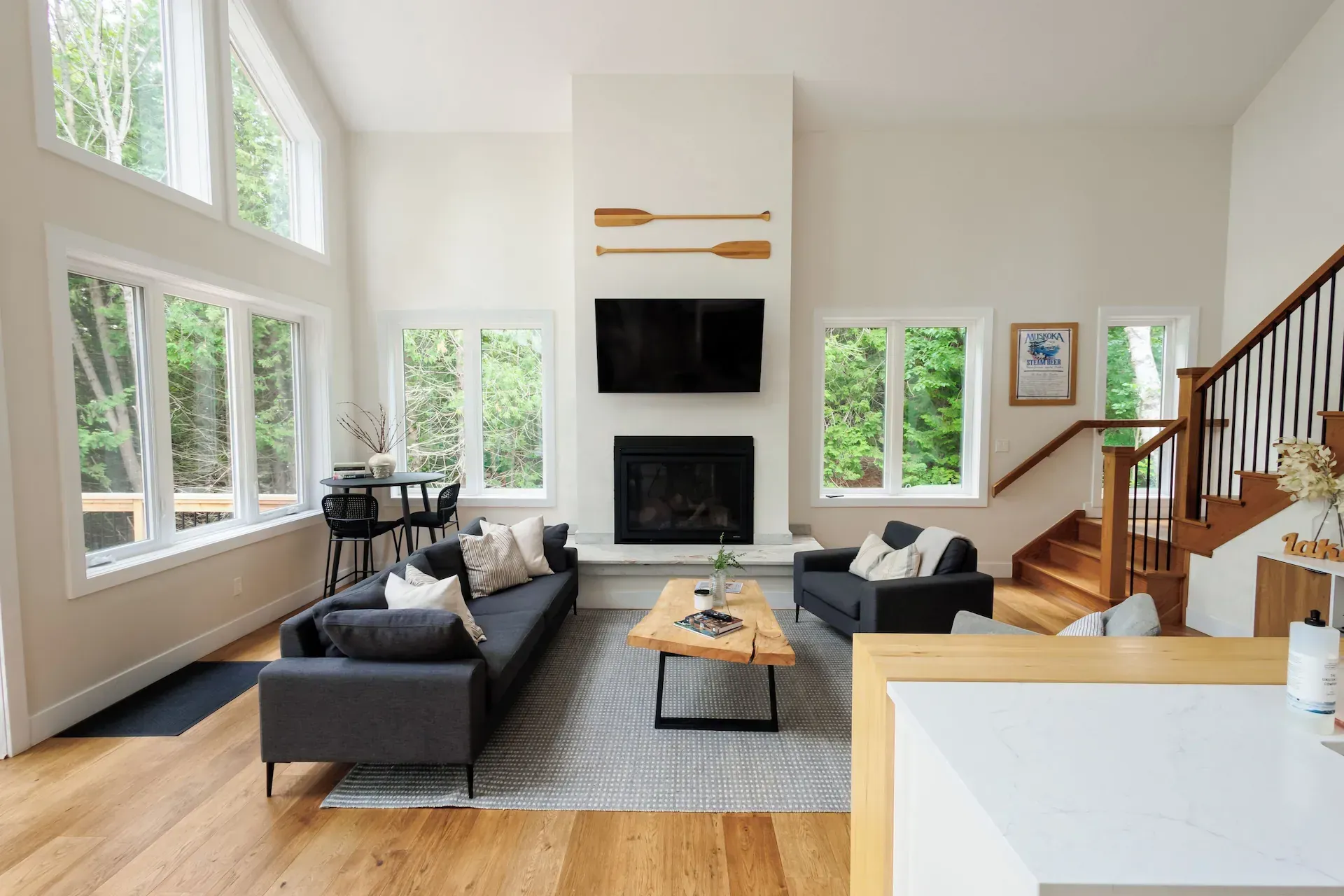 A living room with a couch , fireplace , television and stairs.