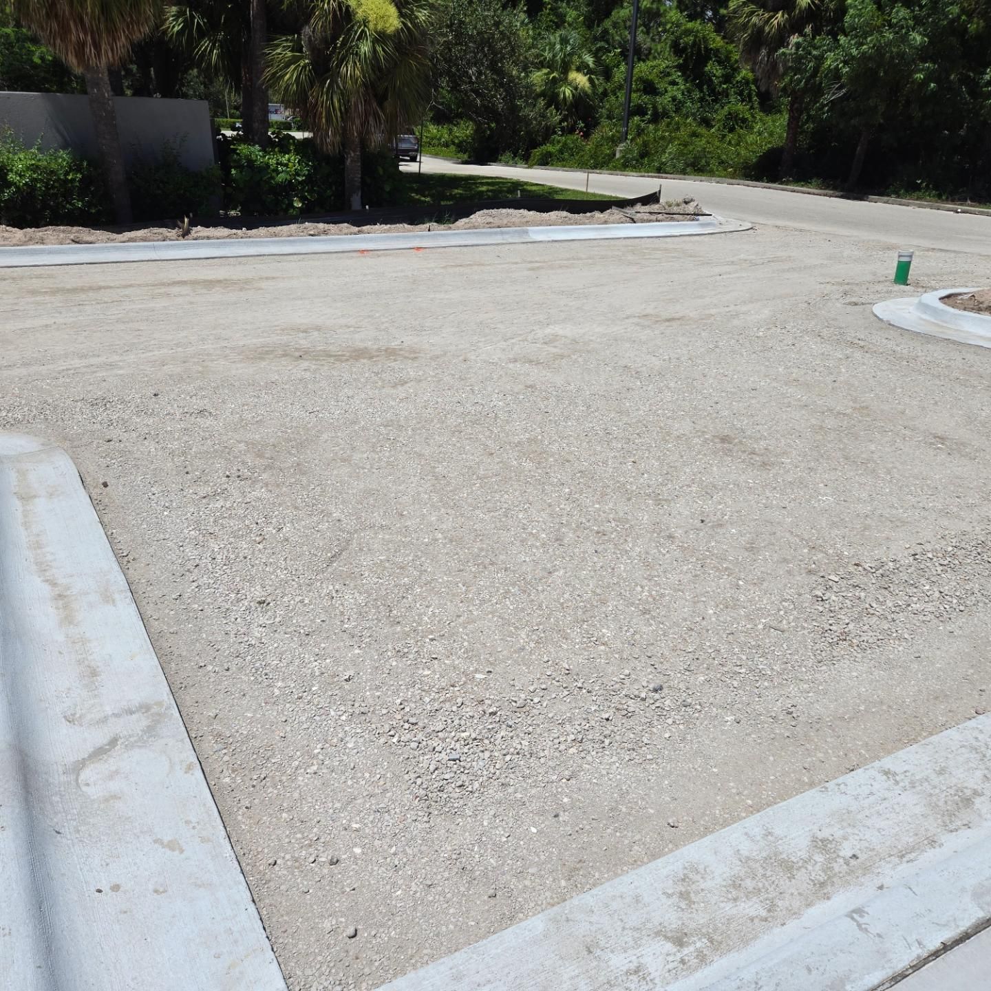 A dirt road with a green cone in the middle