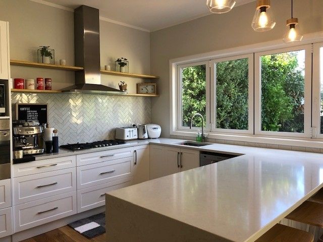 A kitchen with white cabinets and stainless steel appliances